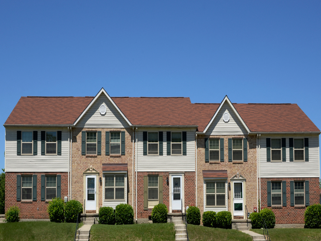 A two story house with a red roof and white siding.